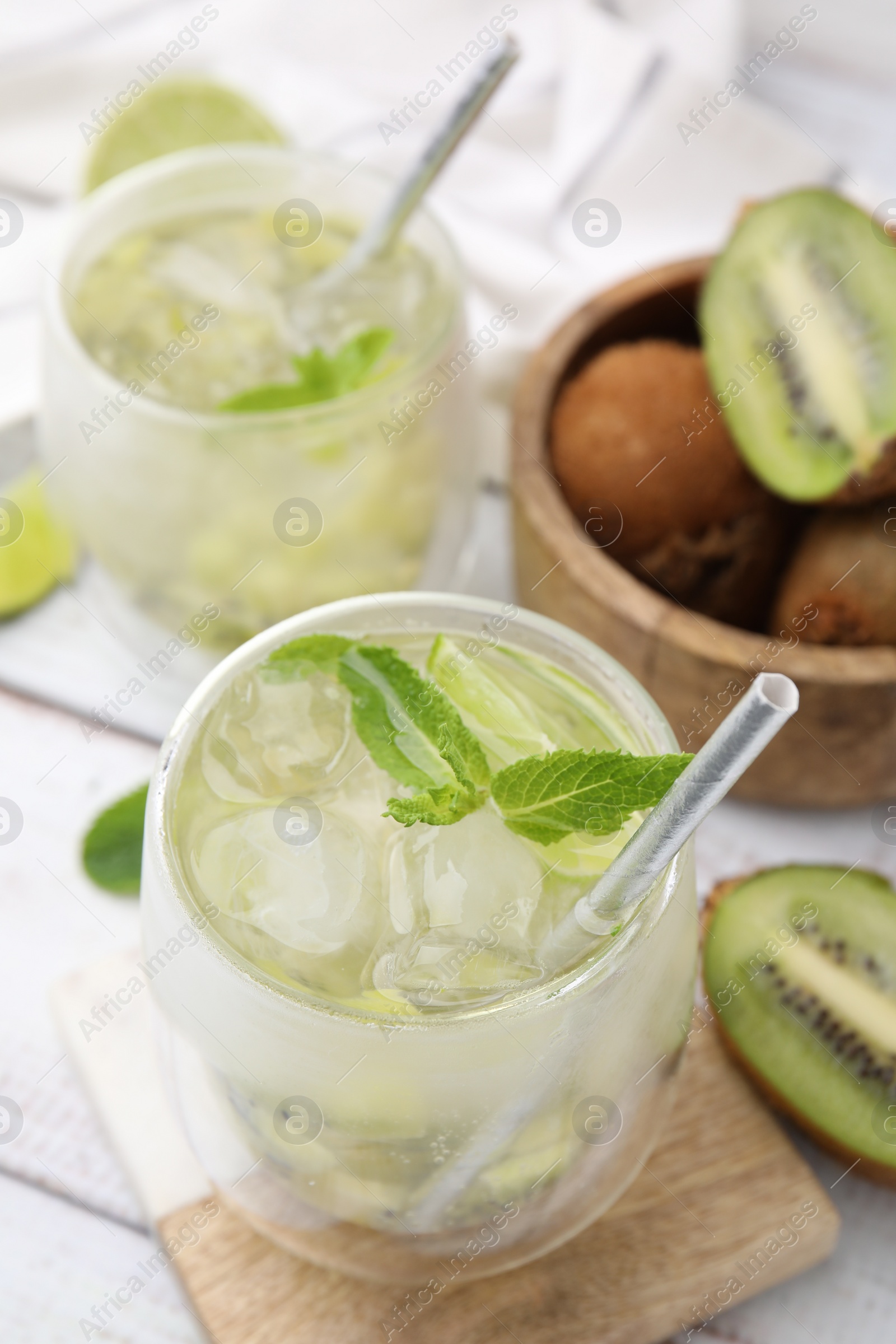 Photo of Refreshing drink with kiwi and mint on white table, closeup