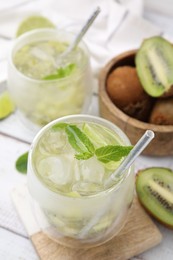 Photo of Refreshing drink with kiwi and mint on white table, closeup
