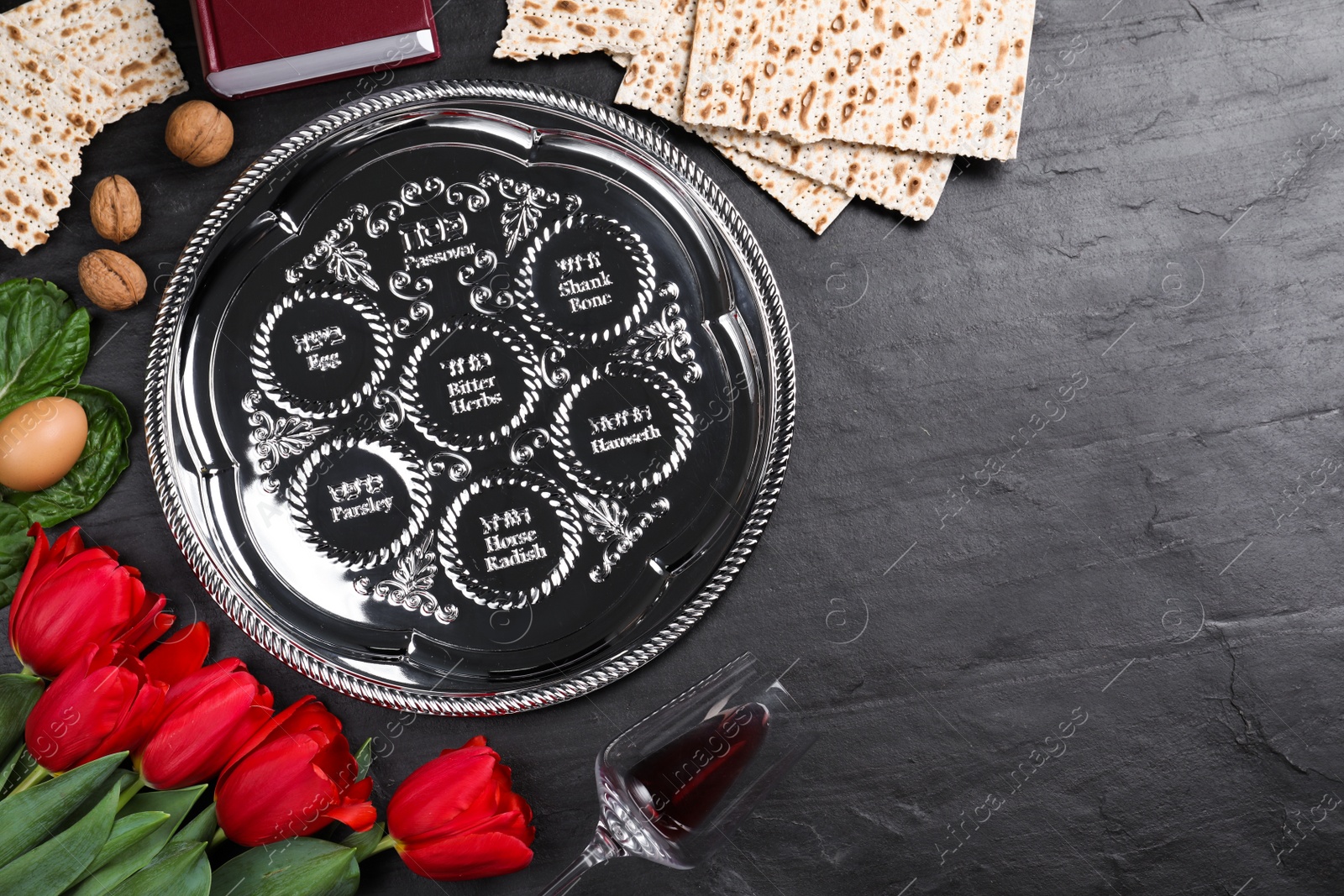 Photo of Flat lay composition with Passover Seder plate (keara) on black table, space for text. Pesah celebration