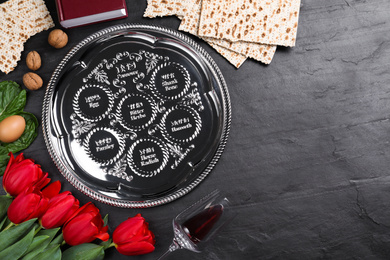 Photo of Flat lay composition with Passover Seder plate (keara) on black table, space for text. Pesah celebration