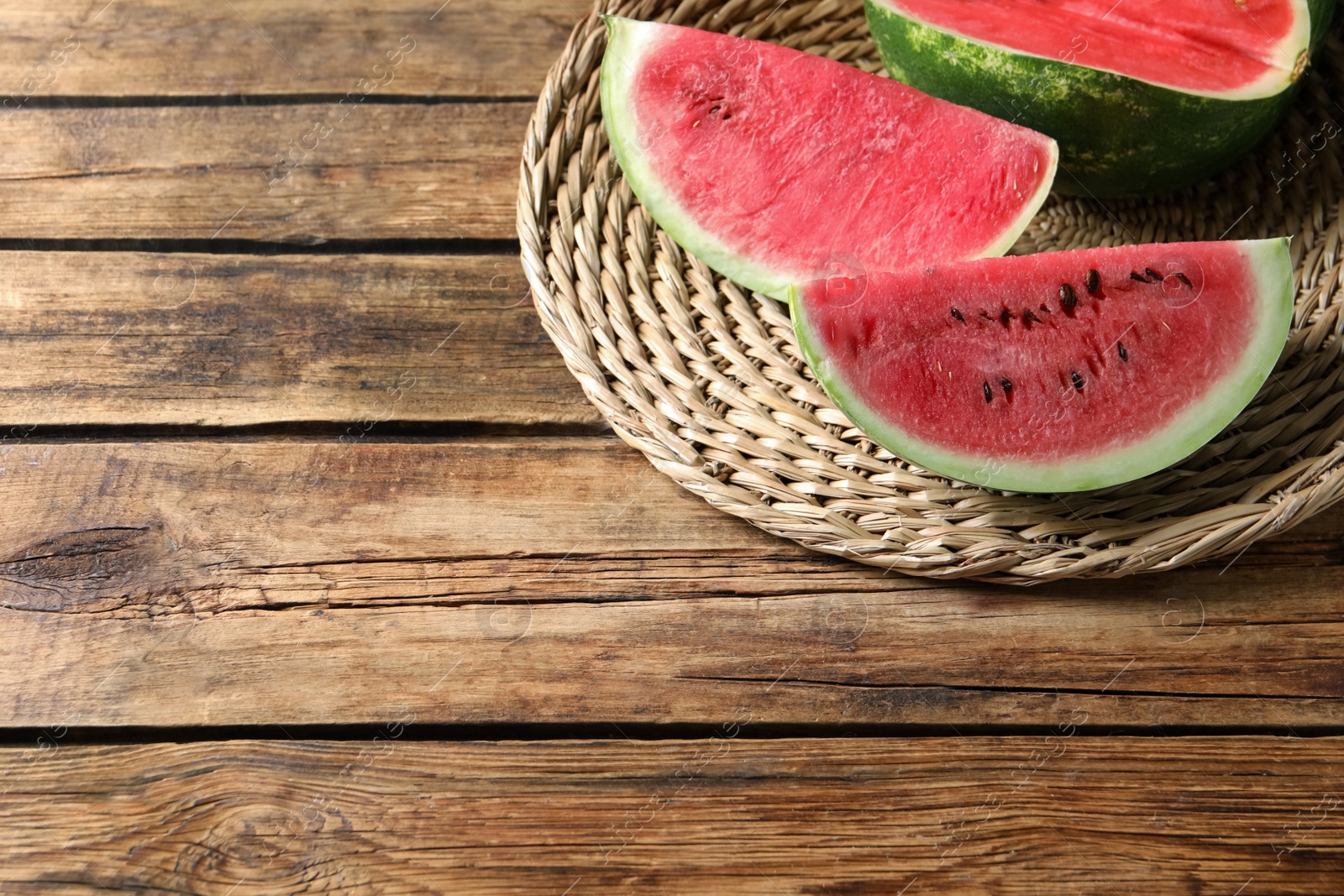 Photo of Delicious fresh watermelon slices on wooden table. Space for text