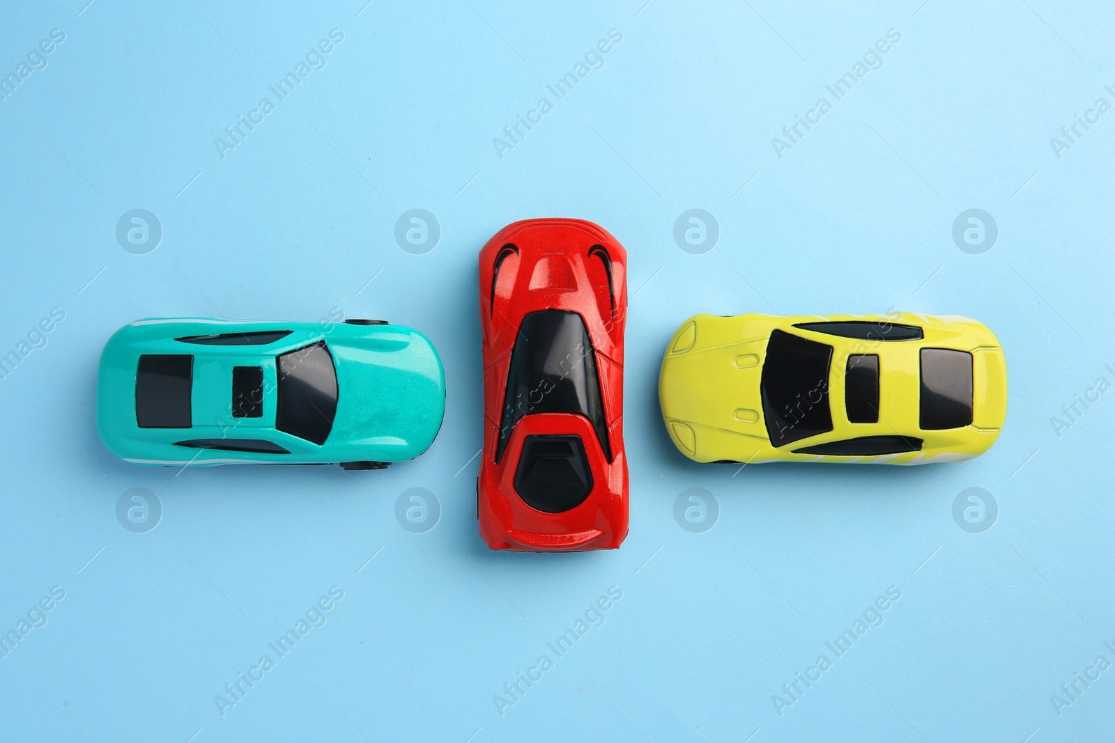 Photo of Different bright cars on light blue background, flat lay. Children`s toys