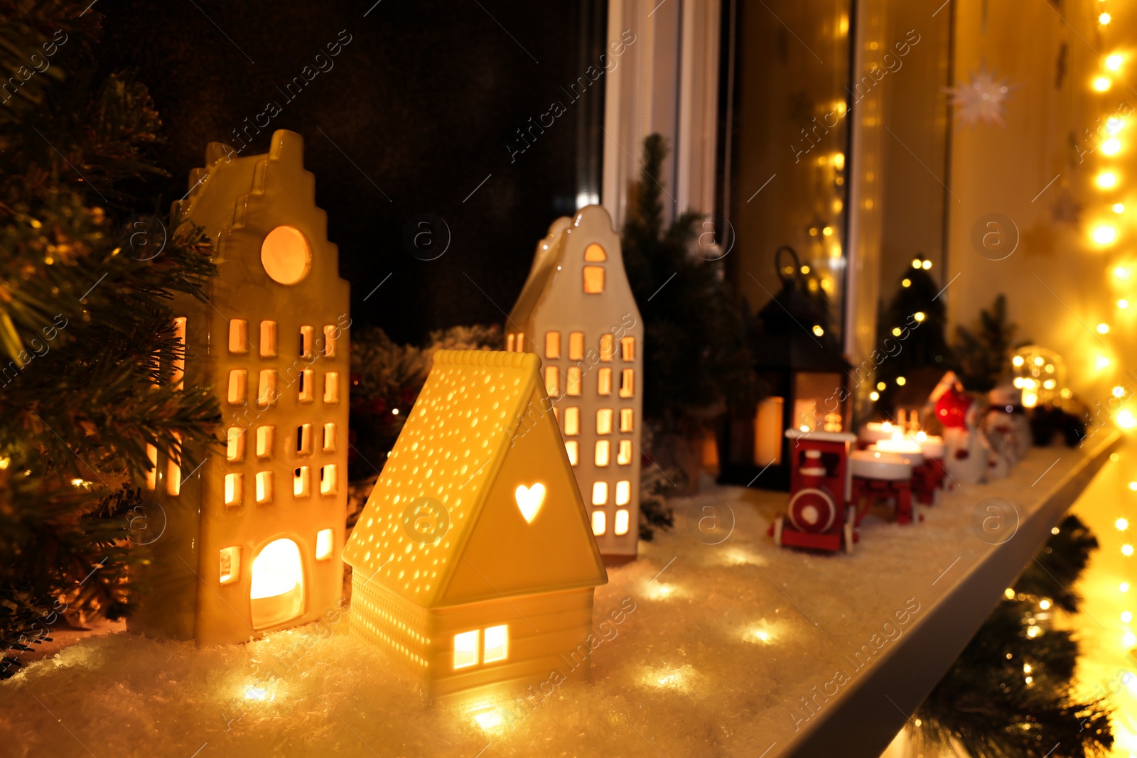 Photo of House shaped lanterns and Christmas decor on windowsill indoors, space for text