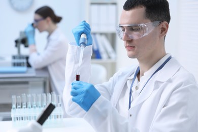 Photo of Scientist dripping sample into test tube in laboratory