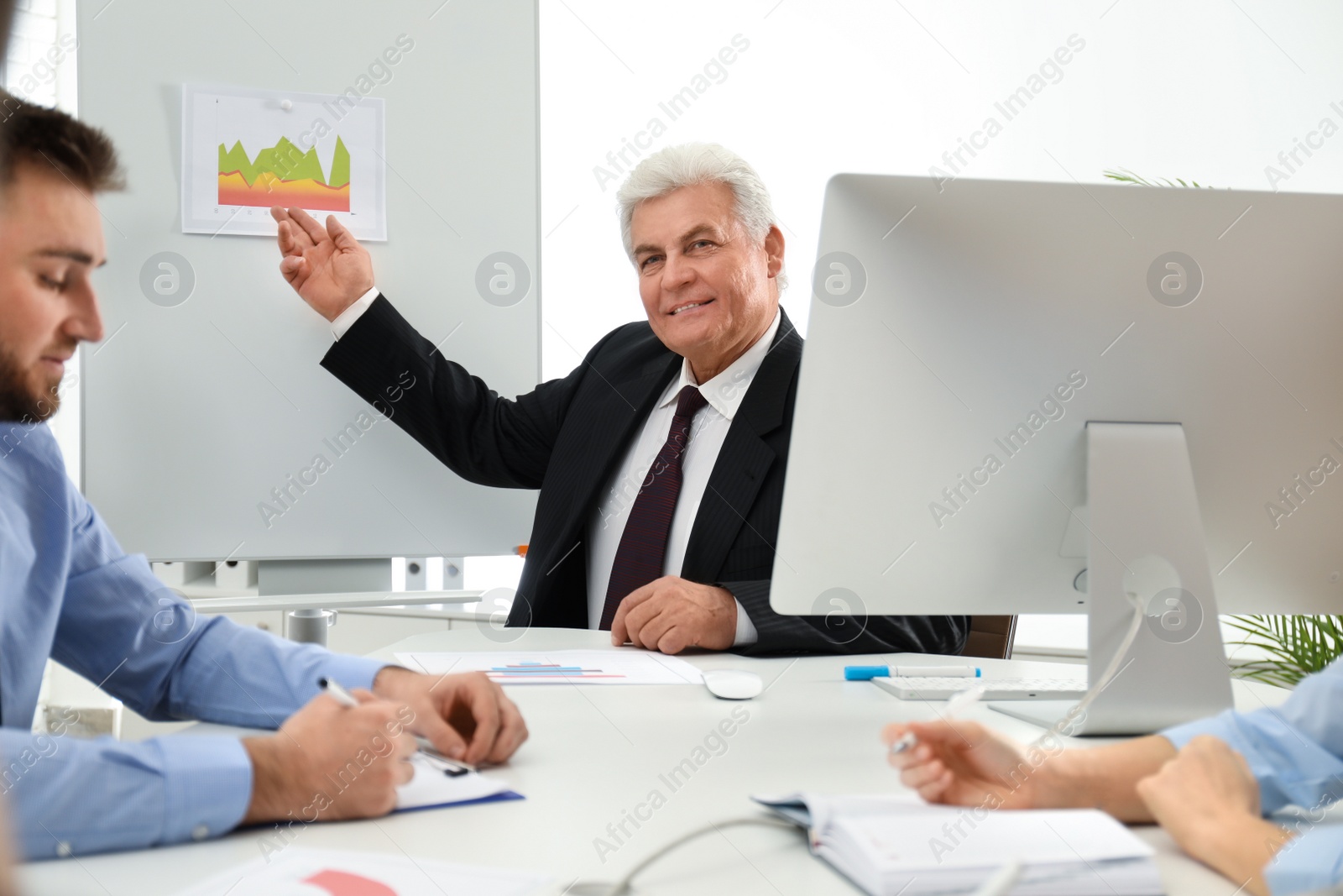 Photo of Senior business trainer working with people in office