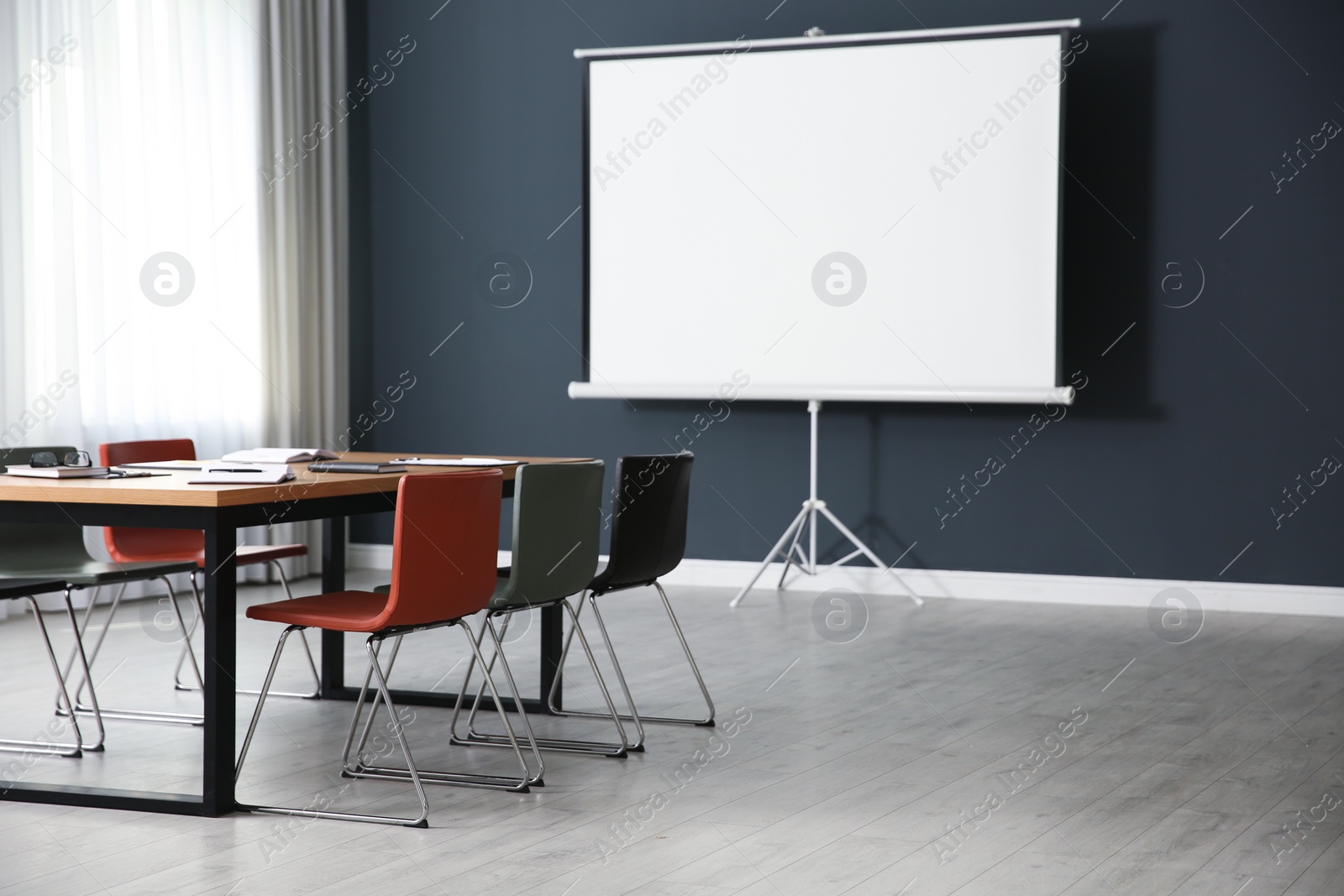 Photo of Modern meeting room interior with large table and projection screen