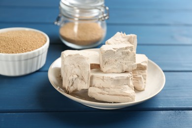 Photo of Compressed and granulated yeast on blue wooden table