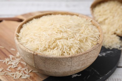 Photo of Raw rice in bowl on table, closeup