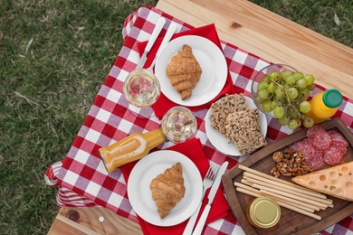 Picnic table with different tasty snacks, top view