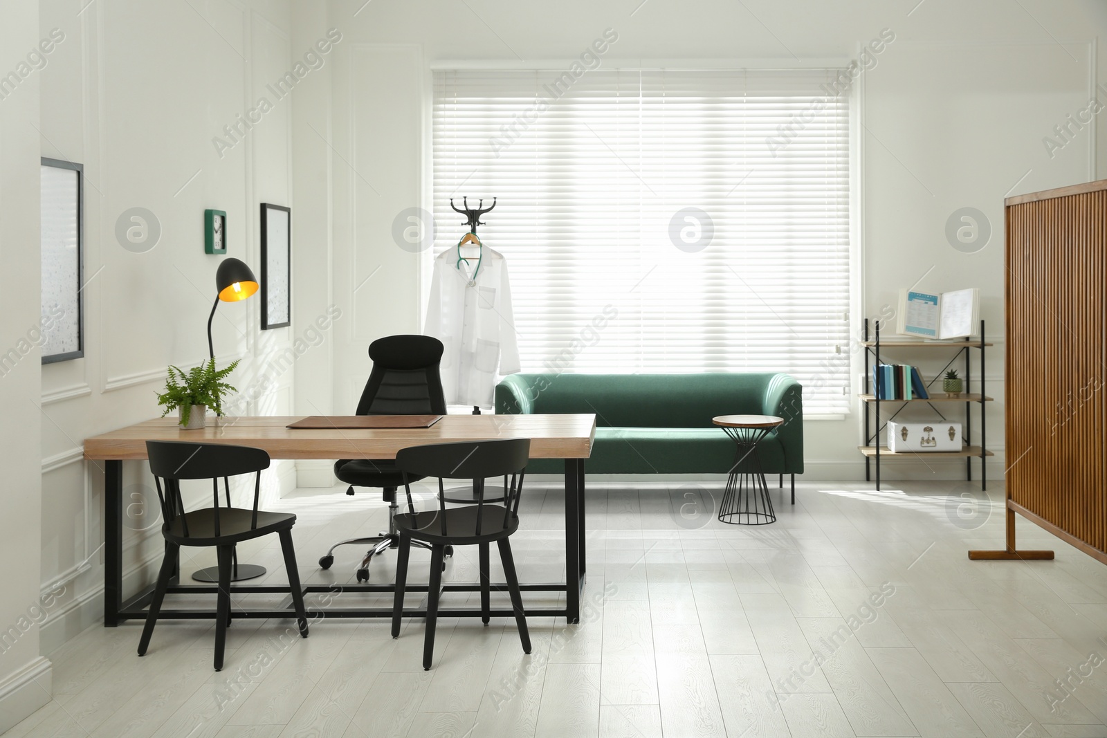 Photo of Modern medical office interior with doctor's workplace and sofa