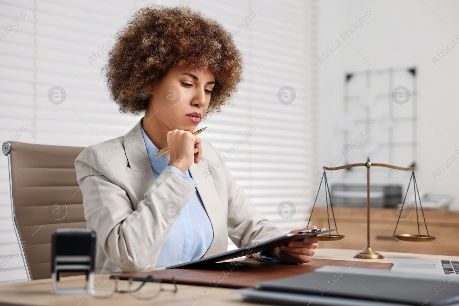 Photo of Notary with clipboard and pen at workplace in office