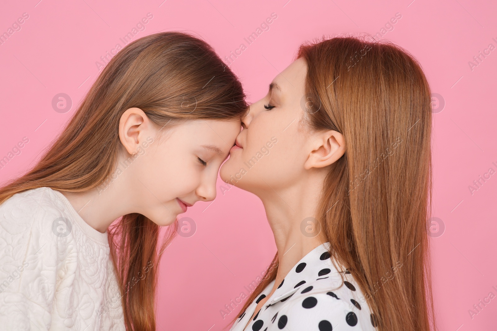 Photo of Portrait of mother and her cute daughter on pink background