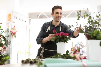 Male florist creating beautiful bouquet in flower shop