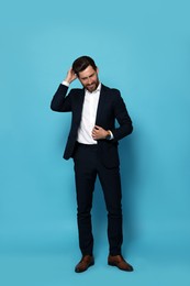 Photo of Smiling bearded man in suit on light blue background