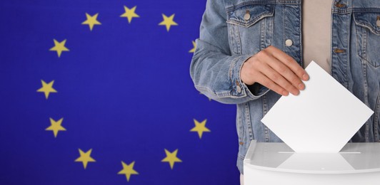 Image of Man putting his vote into ballot box against flag of Europe, closeup. Banner design with space for text