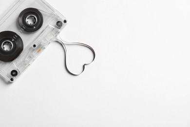Photo of Music cassette and heart made with tape on white background, top view. Listening love song
