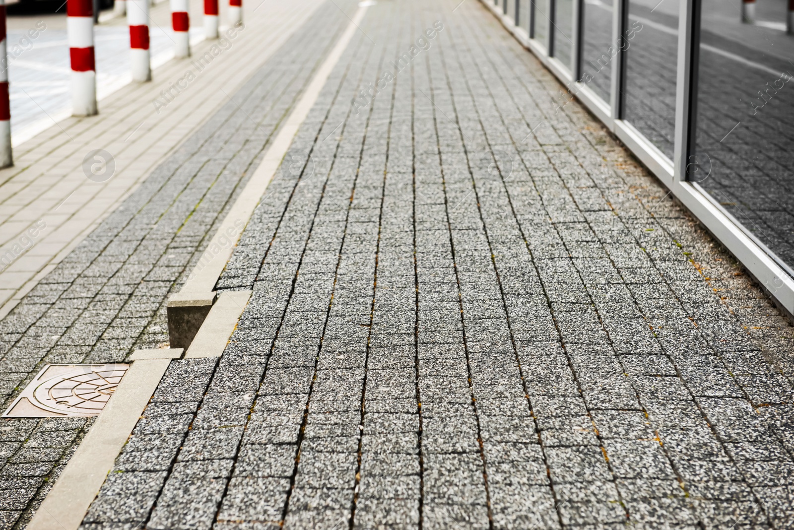 Photo of View on grey stone sidewalk. Footpath covering