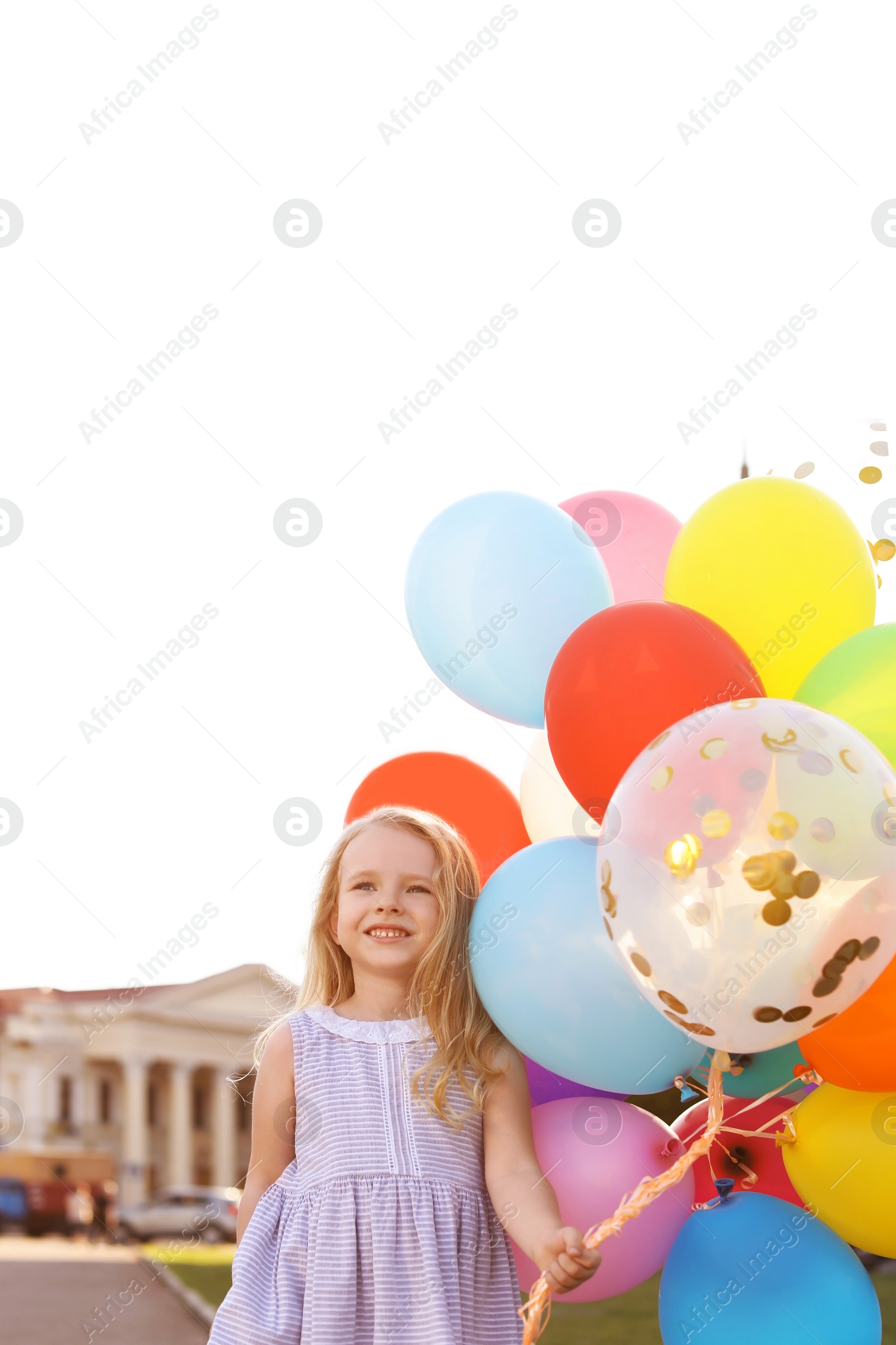 Photo of Cute little girl with colorful balloons outdoors on sunny day