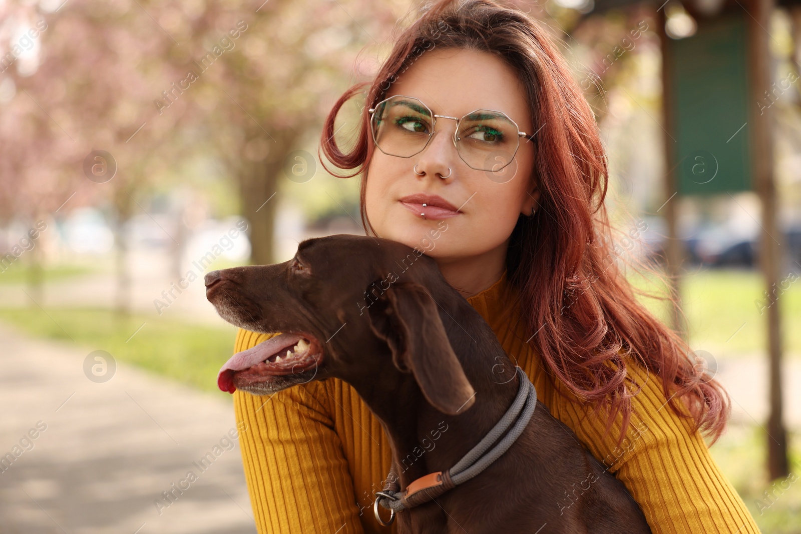 Photo of Woman with her cute German Shorthaired Pointer dog in park on spring day