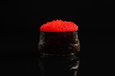 Photo of Delicious sushi with red caviar on black background