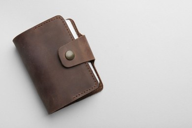 Stylish leather card holder on light grey background, top view. Space for text