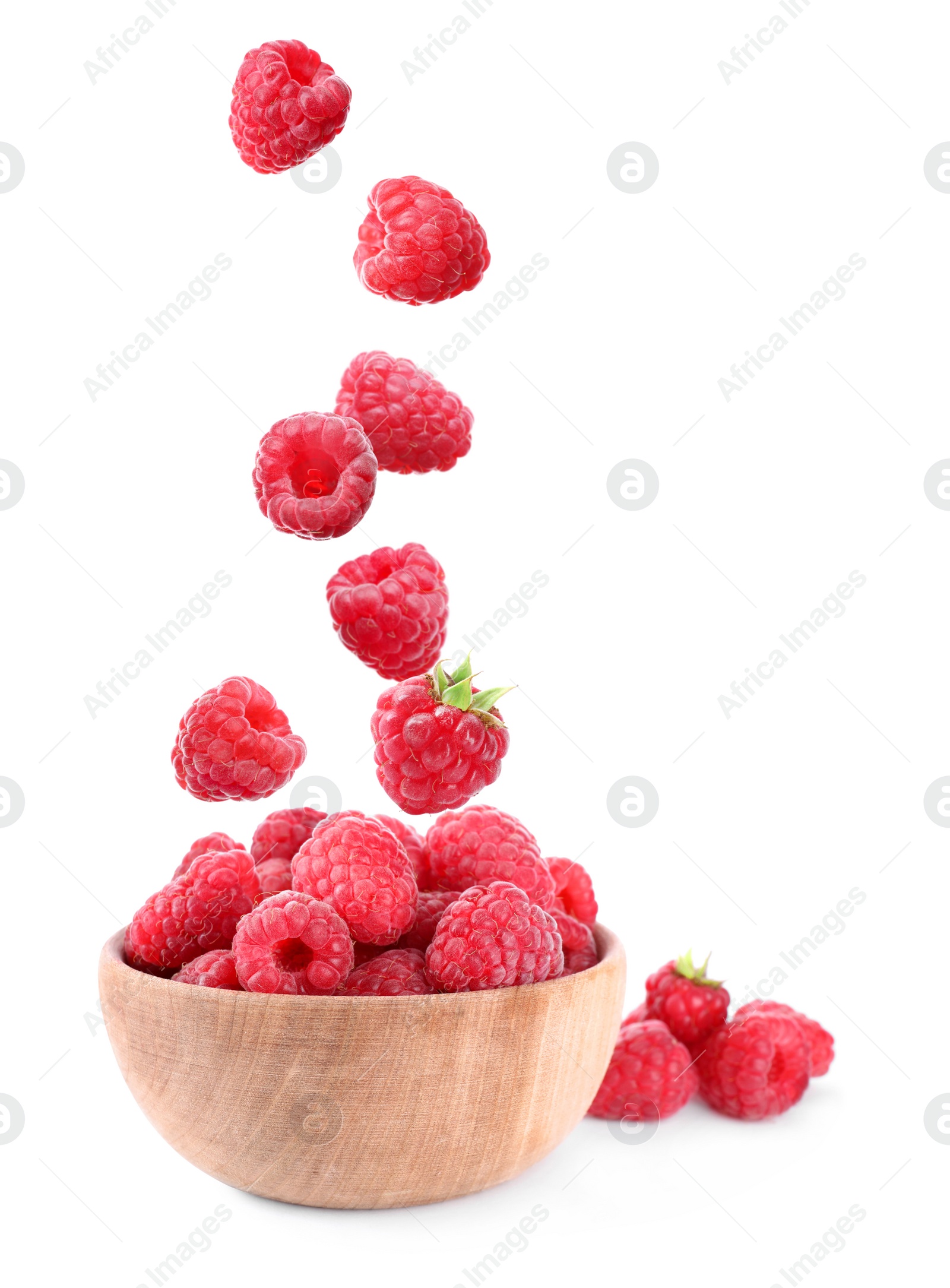 Image of Fresh ripe tasty raspberries falling into bowl on white background