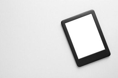Photo of Modern e-book reader with blank screen on white background, top view. Space for text
