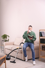 Photo of Man with book suffering from dust allergy at home