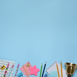 Image of Different stationery and school bell on light blue background, flat lay. Space for text