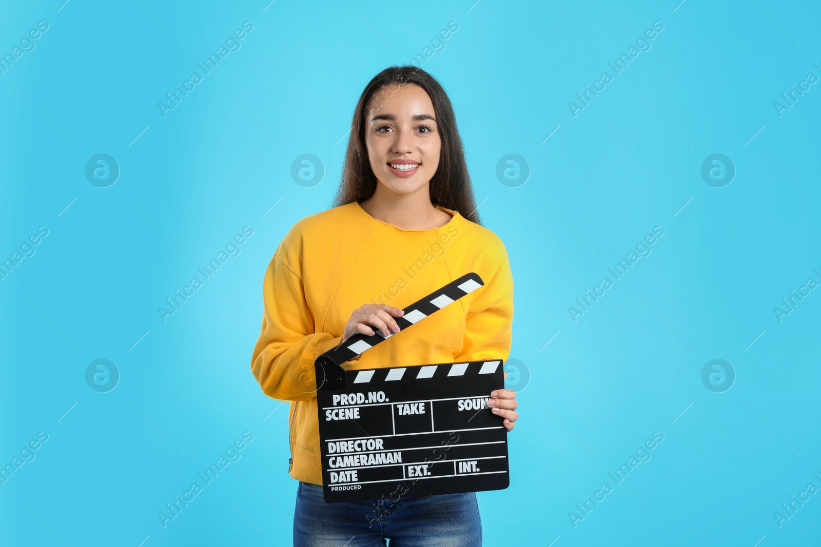 Photo of Woman with clapperboard on color background. Cinema show