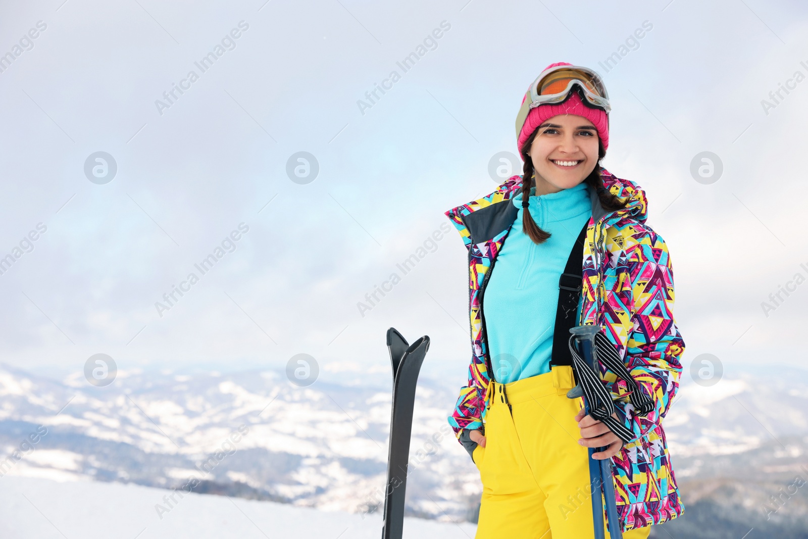 Photo of Young woman with ski on snowy hill. Winter vacation