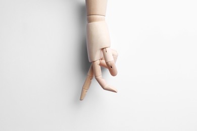 Wooden mannequin hand on white background, top view