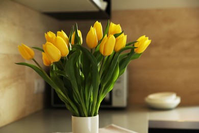 Photo of Bouquet of beautiful yellow tulips in vase indoors