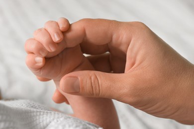 Mother and her newborn baby on bed, closeup view