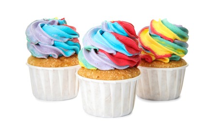 Photo of Three delicious cupcakes with colorful cream on white background