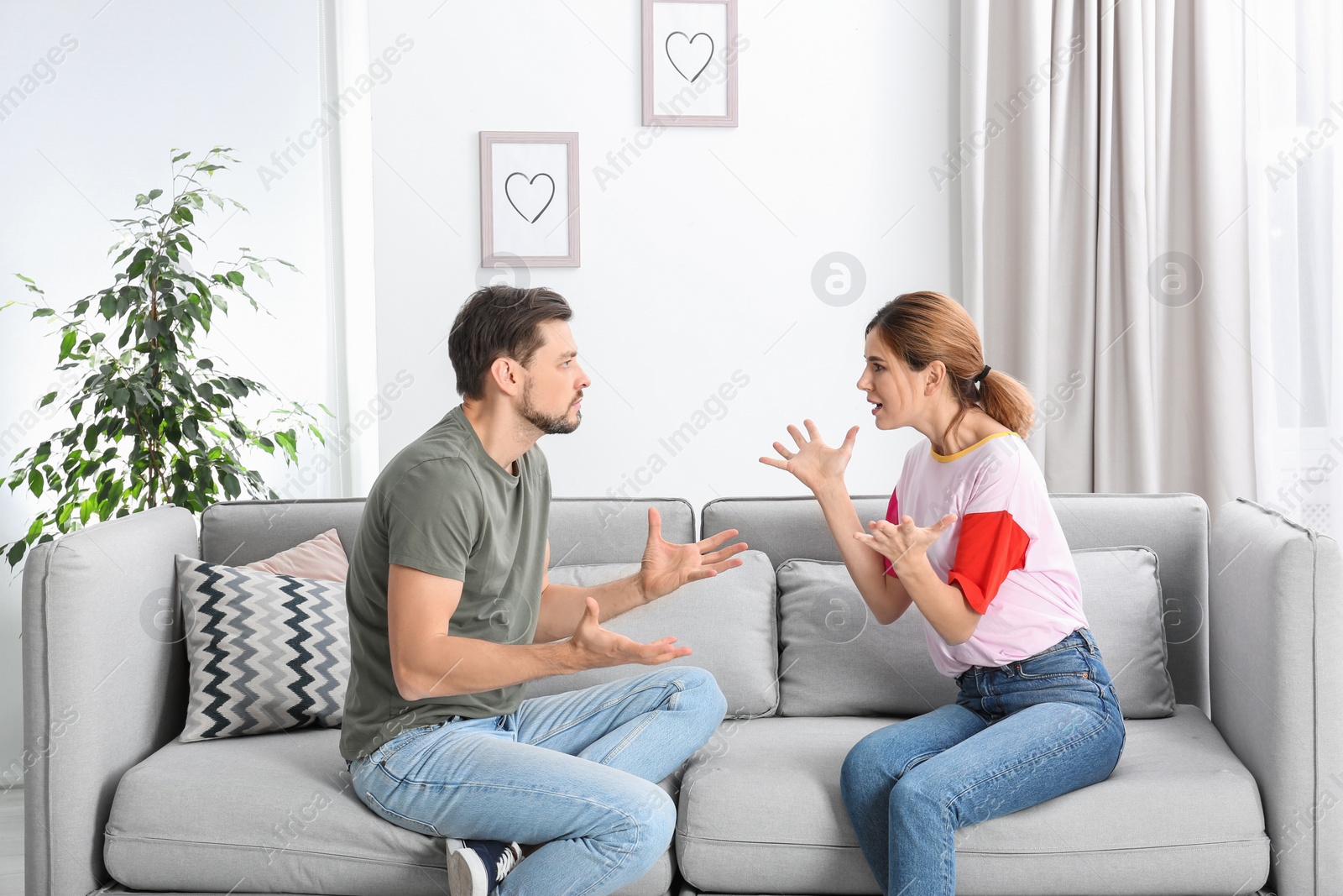 Photo of Couple arguing in living room. Relationship problems