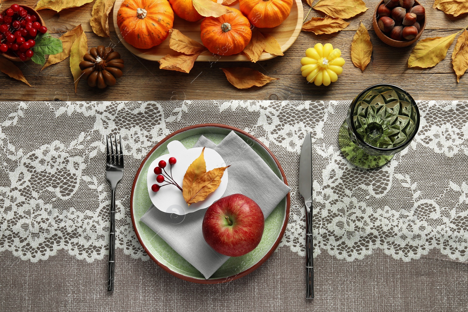 Photo of Happy Thanksgiving day. Beautiful table setting, pumpkin shaped card and autumn decoration on wooden background, flat lay