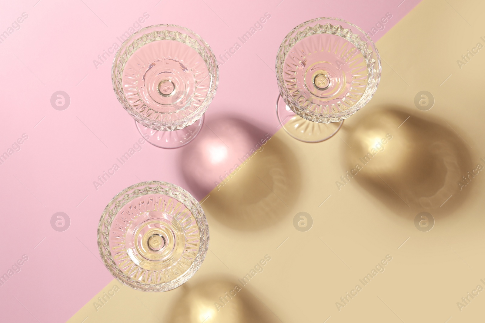 Photo of Glasses of expensive white wine on color background, flat lay