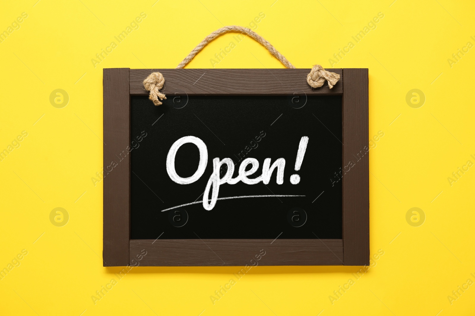 Image of Small chalk board with word Open on yellow background