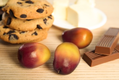 Image of Palm oil fruits and sweets on wooden table, closeup