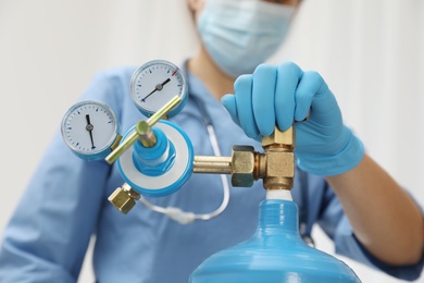 Medical worker checking oxygen tank in hospital room, closeup