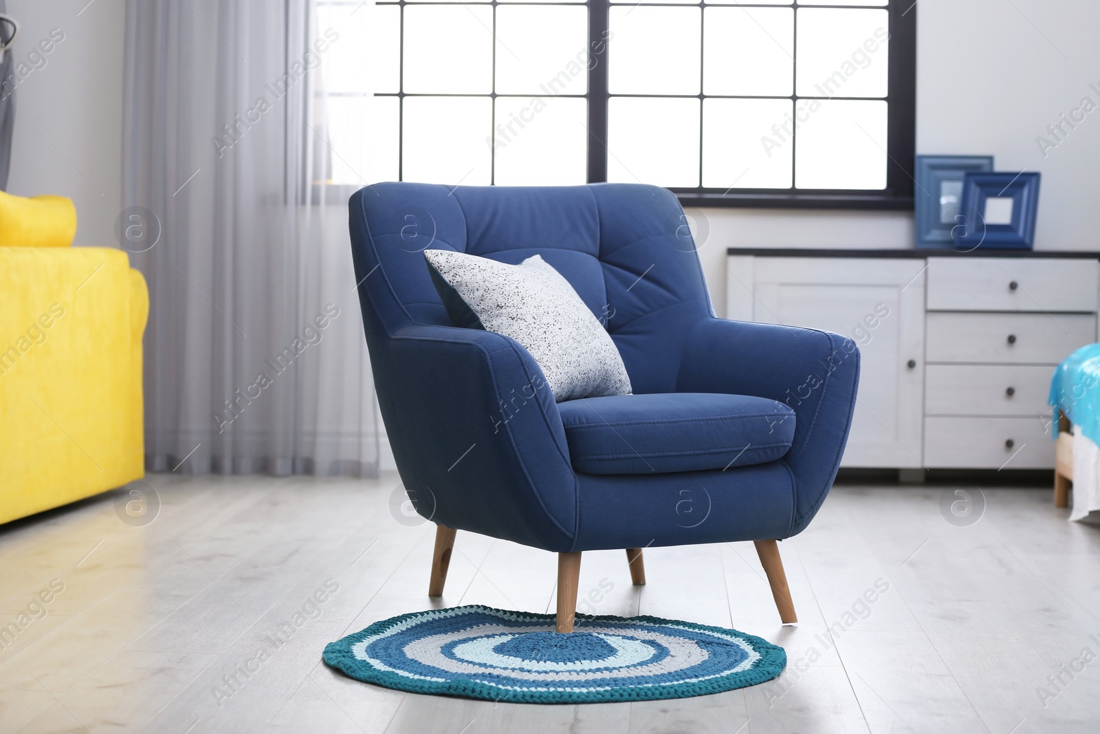 Photo of Stylish room interior with comfortable blue armchair