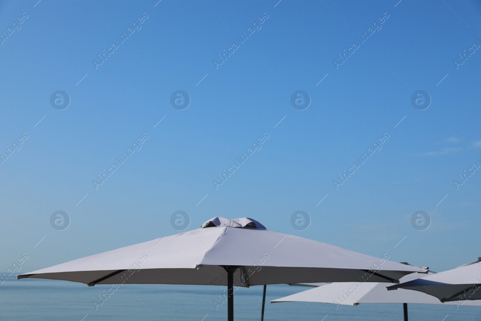 Photo of Beach umbrellas against blue sky on sunny day