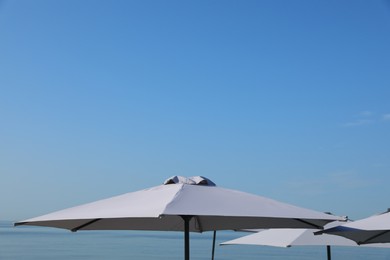 Photo of Beach umbrellas against blue sky on sunny day