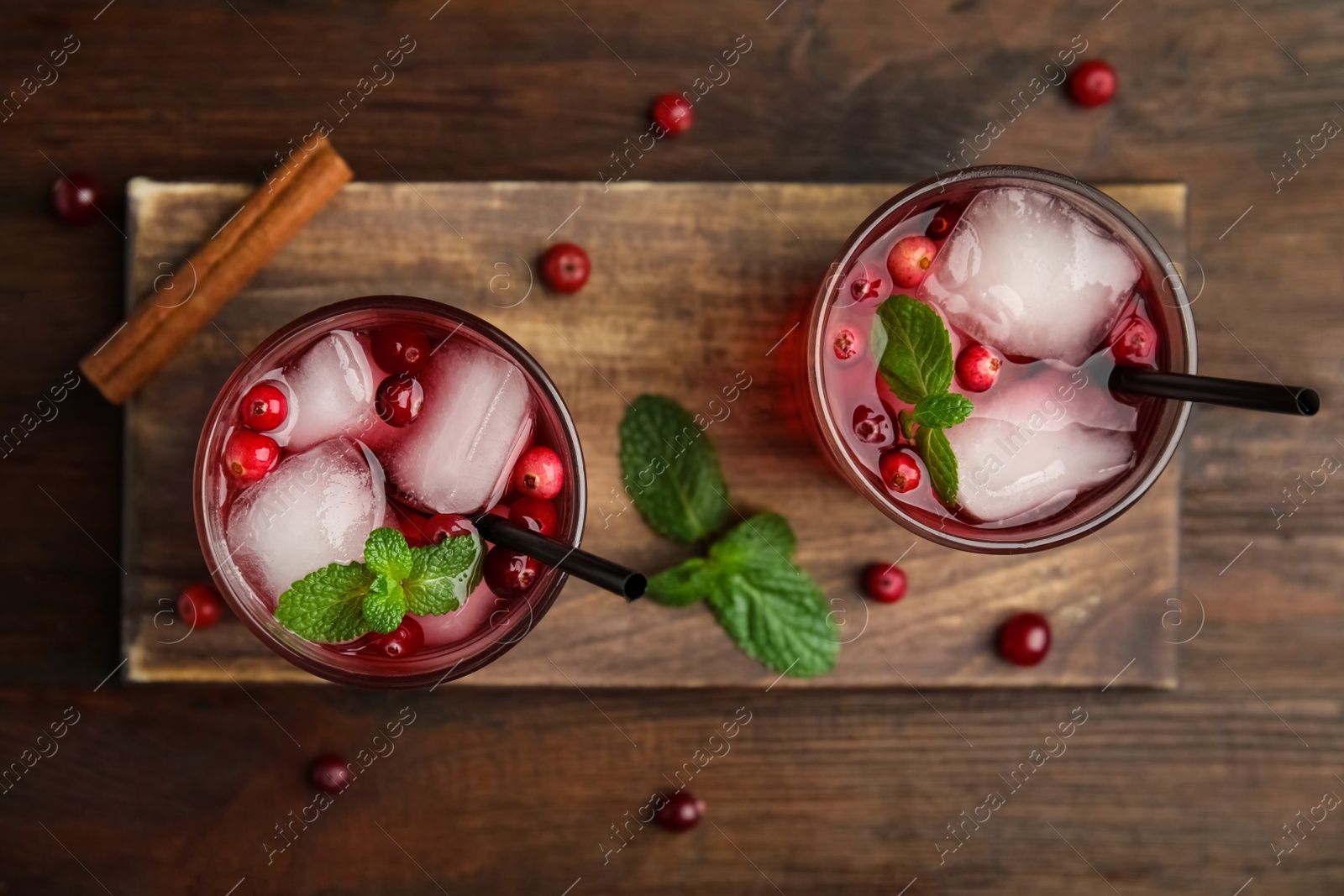 Photo of Tasty refreshing cranberry cocktail with mint on wooden table, flat lay