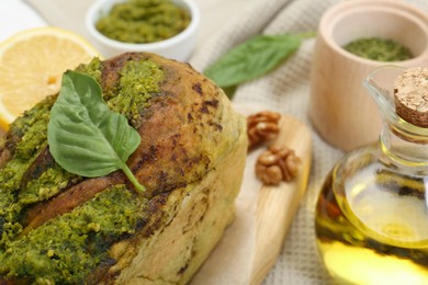Photo of Freshly baked pesto bread with basil served on table, closeup. Space for text