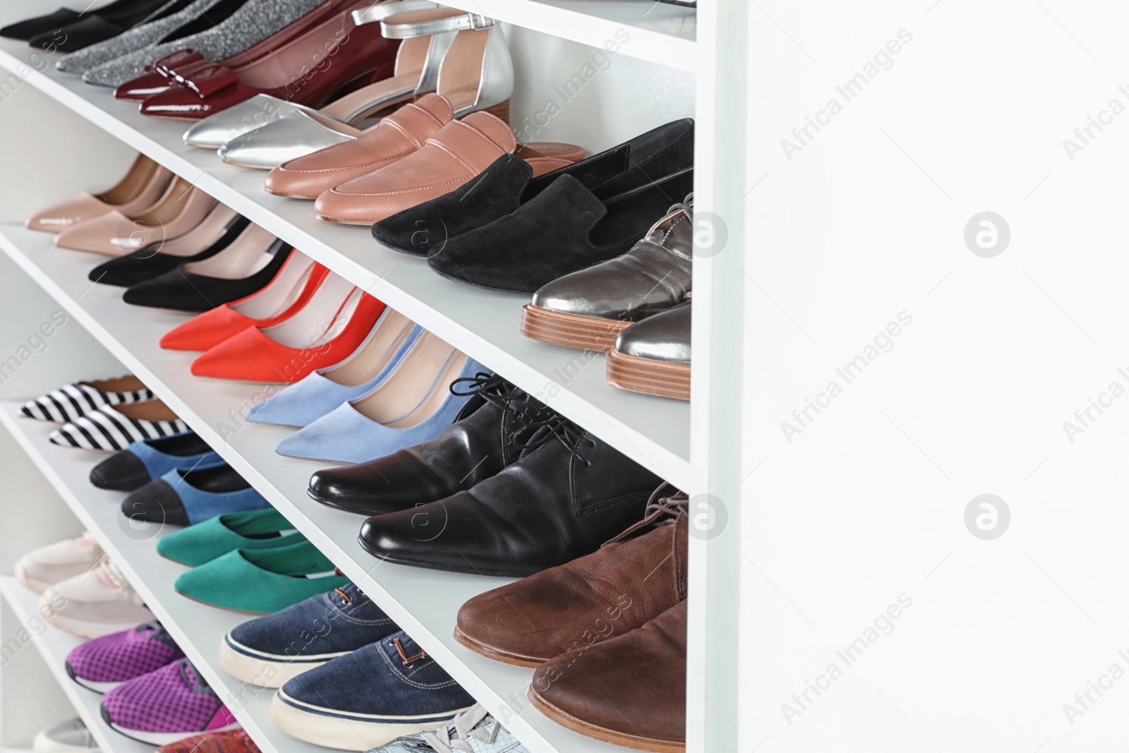 Photo of Shelving unit with different shoes, space for text. Element of dressing room interior