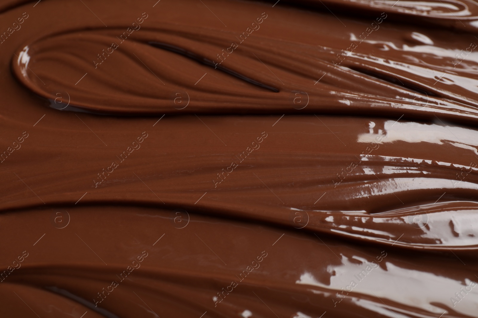 Photo of Tasty milk chocolate paste as background, closeup