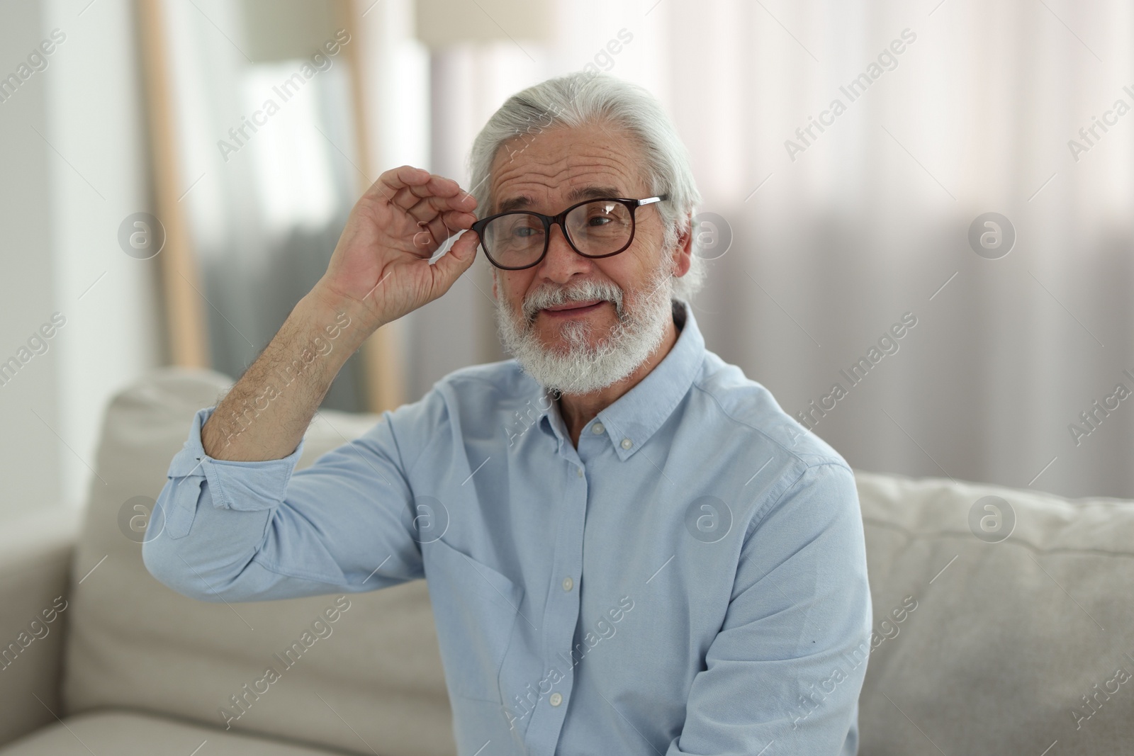 Photo of Portrait of grandpa with stylish glasses on sofa indoors