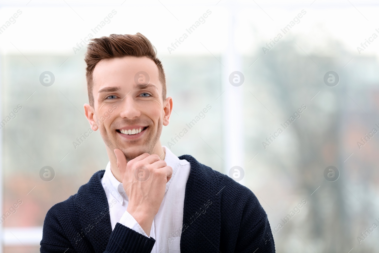 Photo of Young man in casual clothes on blurred background